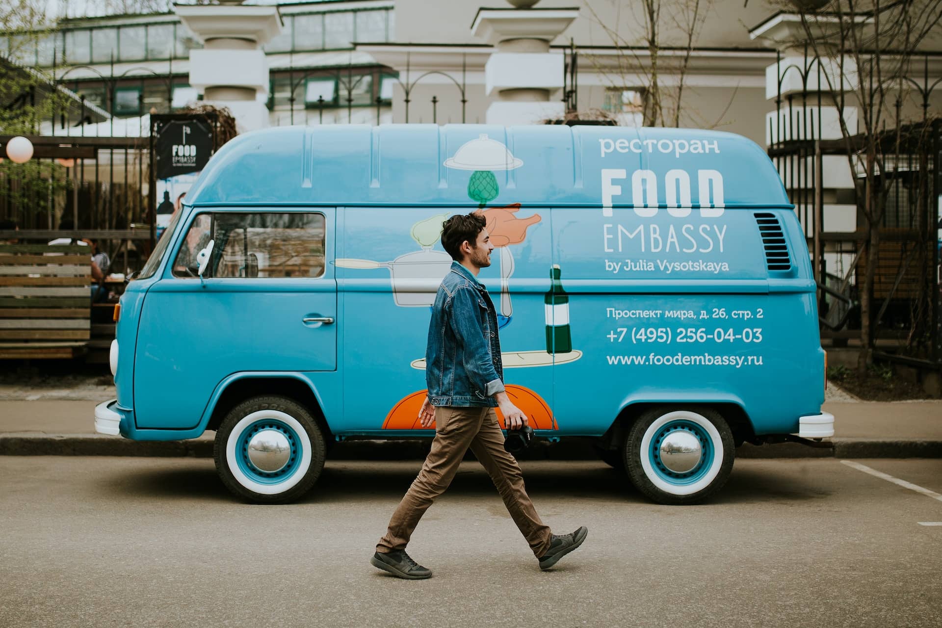 Man walking in the street in front of a blue van